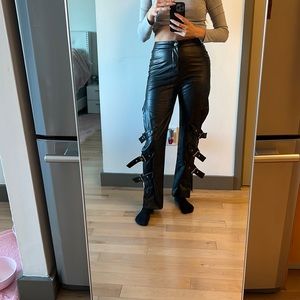 Black faux leather pants with belts